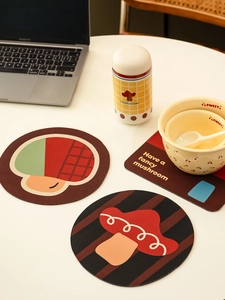 Close-up of cute mushroom pattern coasters and ceramic tableware on a white desk