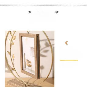 Detail of creative gold metal ring photo frame with sliding wood design and leaf accents