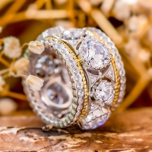 Luxury two-tone wide band ring with pave-set zircon stones and gold-tone braided edges
