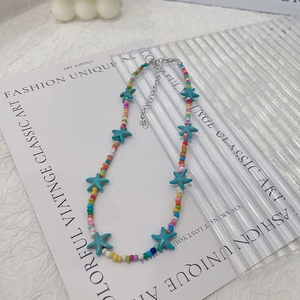 Close-up of bohemian beaded necklace featuring blue starfish pendant and extension chain