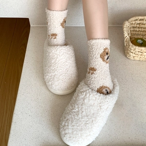 Detailed view of warm cream coral fleece socks with cute brown bear patterns