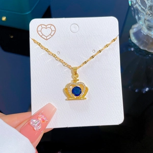 Golden crown pendant necklace with blue gemstone and zircon on a fashion jewelry card