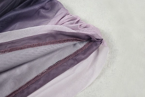 Macro detail of breathable mesh fabric with purple gradient tones and neat overlock stitching