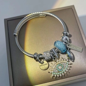 Handmade twisted rope evil eye bracelet in silver and gold with blue charms