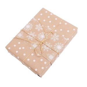 Double-sided vintage kraft Christmas wrapping paper with white snowflake patterns and jute rope