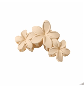 Close-up of three beige matte petal flowers on a vintage style shark hair clip