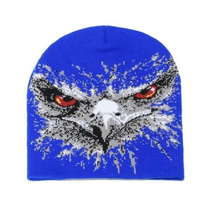 Macro shot of bright blue knitted beanie featuring a detailed eagle head jacquard pattern
