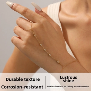 Detail of a gold finger bracelet with clear round and olive cubic zirconia on model