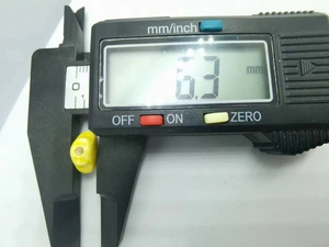 Detailed measurement of a 6.3 mm yellow ceramic bead using a digital caliper