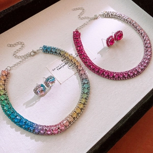 Detailansicht der Halsketten und Ohrringe mit Strasssteinen in Pink und Regenbogenfarben