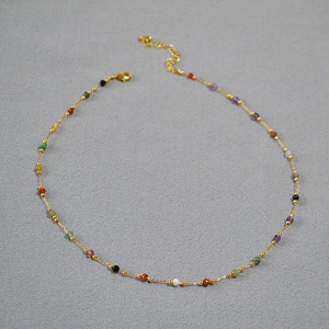 Detailed view of adjustable gold necklace with colorful faceted stone beads and lobster clasp
