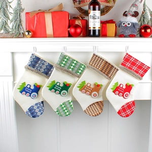 Set of four beige Christmas stockings with train patterns hanging on a white fireplace
