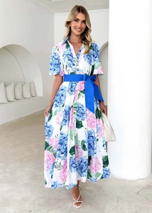 Detail of floral printed maxi dress with vibrant blue belt and V-neckline on white fabric