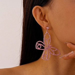 Close-up of model wearing a luxury pink butterfly earring with sparkling zircon crystals