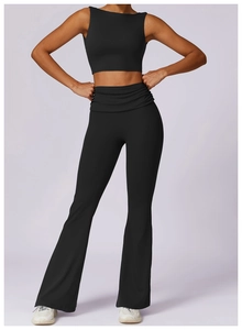 Detail of high-waisted black yoga flares and cropped vest set in matte finish