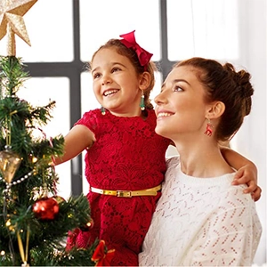 Red reindeer earrings and festive accessories worn in a warm Christmas setting