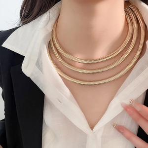 Detail of golden triple-layered snake chain necklace on model for professional look