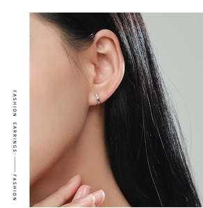Close-up of elegant micro-set silver hoop earring worn on a model ear lobe
