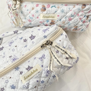 Detail view of quilted cotton cosmetic bags with cute bear prints and ribbon zippers
