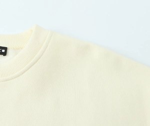 Dettaglio di una felpa in velluto crema con scollo a costine e cuciture di alta qualità