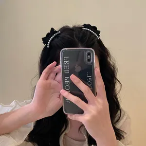 Detail of French style black bow hair clip with pearls worn on the side by a model