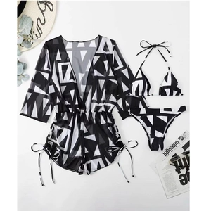 Flat lay of black and white geometric print bikini set with matching mesh cover-up wrap