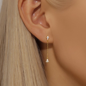 Close-up of elegant gold long tassel earring with marquise and pear-cut zircon crystals