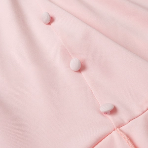 Detail of pink twill fabric with matching fabric-covered buttons on the dress placket