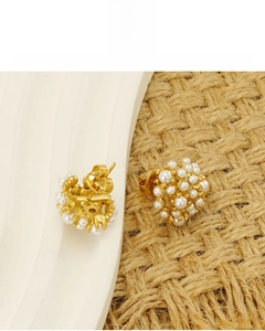 Detail of 18k gold plated pearl cluster earrings on white display tray and woven mat