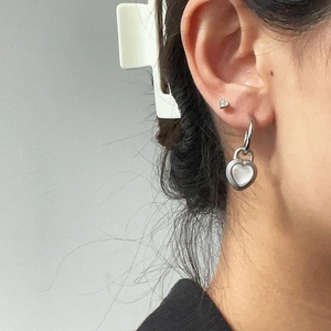 Silver titanium steel heart padlock earrings with cat eye stone worn on a female model