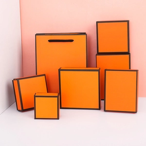 Luxe oranje sieradendoosjes en papieren zak met elegante zwarte randen als geschenkverpakking