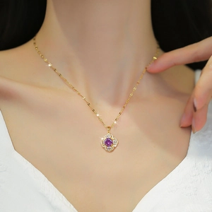 Collier en or avec pendentif trèfle, pierre violette et zircons porté par un mannequin