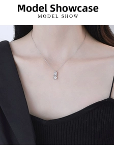 Detailed view of sterling silver cat pendant with teardrop zircon worn by a model