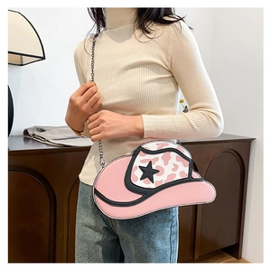 Close-up of pink cowboy hat shaped crossbody bag with black star and metal chain