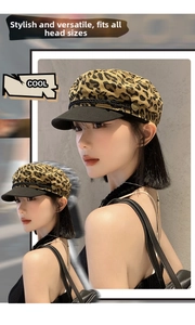 Close-up of leopard print baker boy hat with black brim and decorative golden button detail
