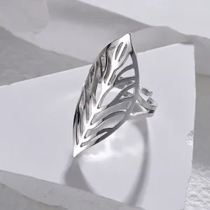 Detail of silver hollow leaf ring with intricate textures on white marble stand