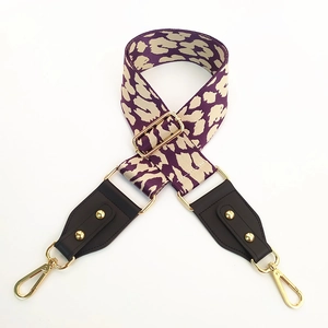 Detail of leopard print bag strap with gold rivets and metallic lobster clasps