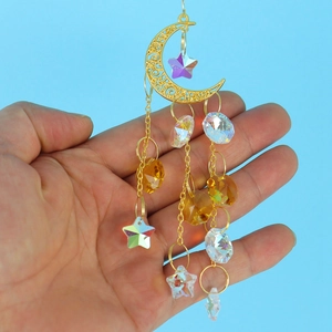 Macro view of crystal moon suncatcher with gold crescent and sparkling faceted glass beads