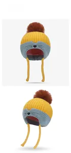 Detail view of child winter knit hat with earflaps, yellow color block and cat embroidery