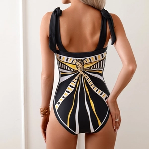 Detail of swimsuit back featuring black, white and gold sunburst print and bow tie straps