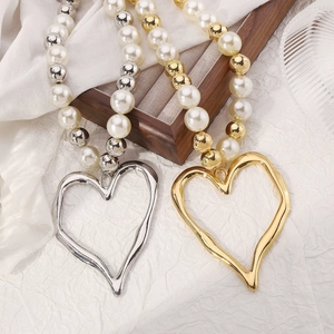 Detail of hollow heart pendant necklace with mixed pearls and metallic beads