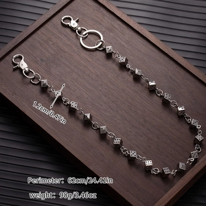 Detail of punk style dice chain with metal lobster clasp and O-ring on wood tray