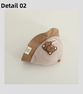 Detail view showing corduroy texture and teddy bear embroidery on baby sun hat
