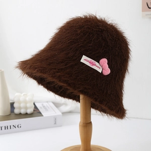 Close-up of brown fuzzy bucket hat with a cute pink bow and sweet design details