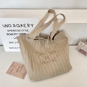 Detail of striped canvas tote bag with you are so special brown embroidery text