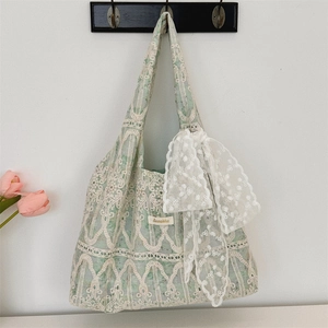 Close-up of lace shoulder bag with a floral pattern and large white bow detail