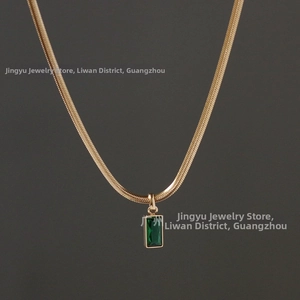 Détail de la pierre rectangulaire vert émeraude sur une chaîne serpent plaquée or 18k