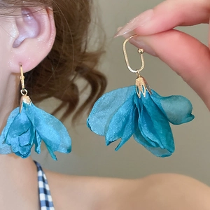 Close-up of lightweight teal fabric petal earrings with golden oval hook details