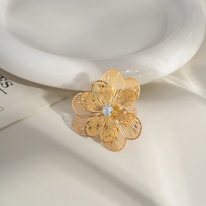 Detail of 18K gold camellia ring featuring hollow petals and a sparkling center zircon