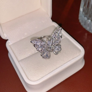 Bague papillon ajourée en zircon argenté présentée dans un écrin de bijoux blanc luxe